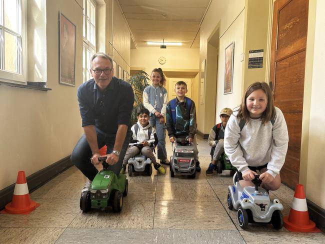 Bürgermeister André Dora beim Bobbycarrennen mit Kindern im Rathaus.