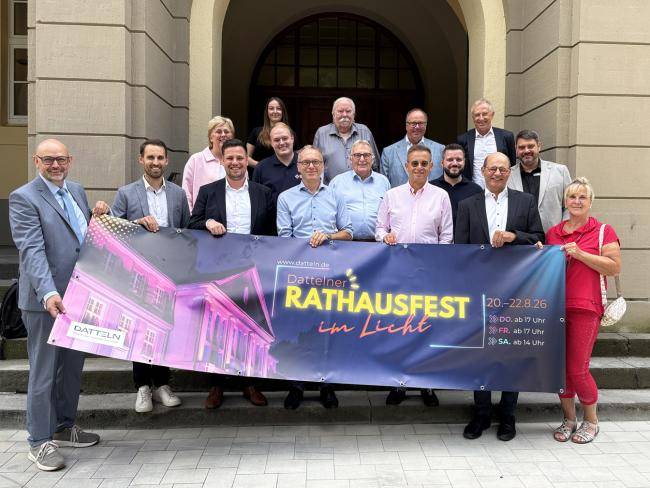 Stadtverwaltung und Sponsoren vor dem Rathaus mit Banner zum Rathausfest