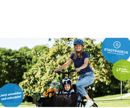 Eine Frau fährt mit einem Lastenrad, in dem ein Kind sitzt.
