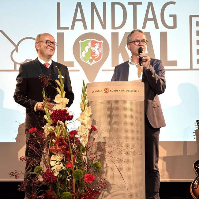 Landtagspräsident André Kuper mit Bürgermeister André Dora auf der Stadthallenbühne